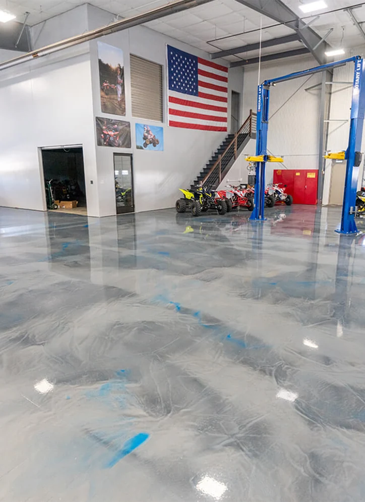 A silver and blue metallic epoxy floor with swirled movement in a finished shop.