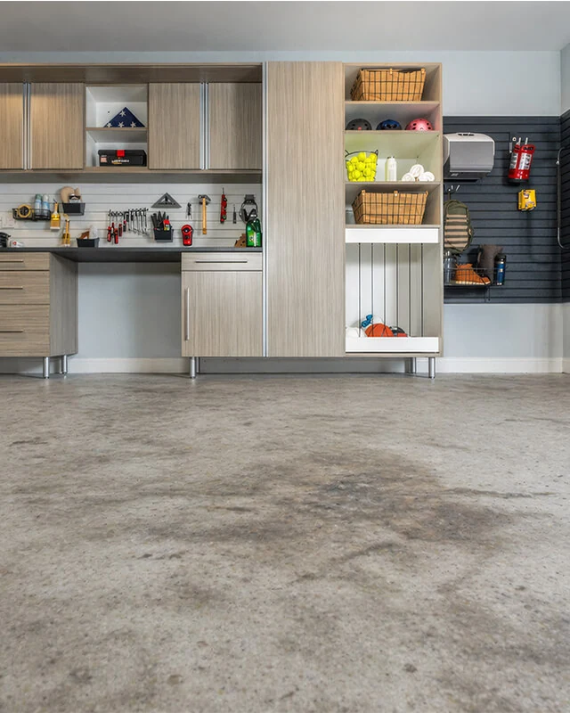 A bare, stained concrete garage slab before any prep work.